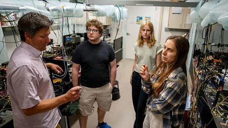 A group of people talk in a lab