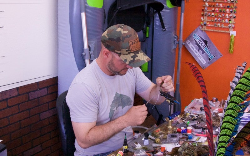 Haselip works with small metal tools at a workbench