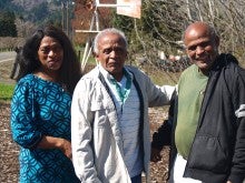 Members of the Matthews Family Gospel Singers stand outside near an orchard and a small windmill.
