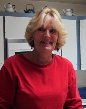Laila Griffith stands in a kitchen wearing a red sweater.