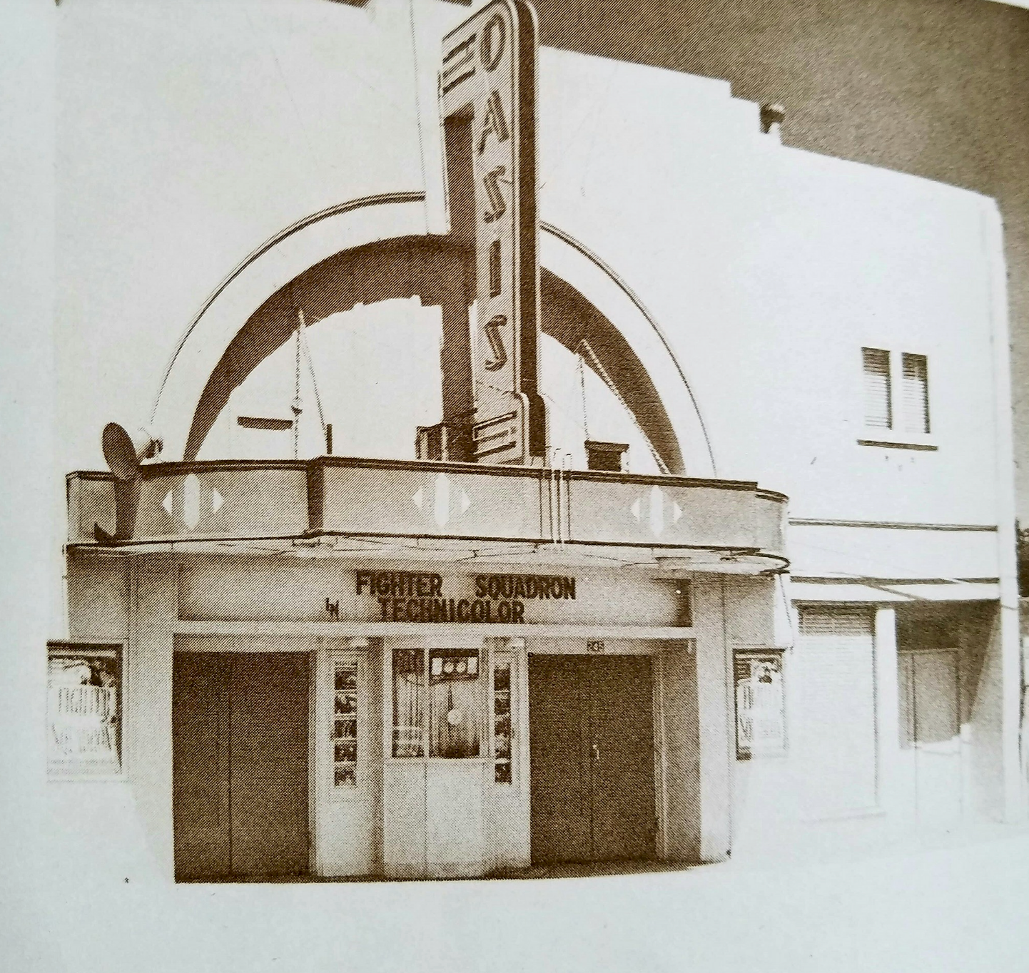 Front view of the Oasis Theater with its marquee displaying Fighter Squadron in Technicolor.