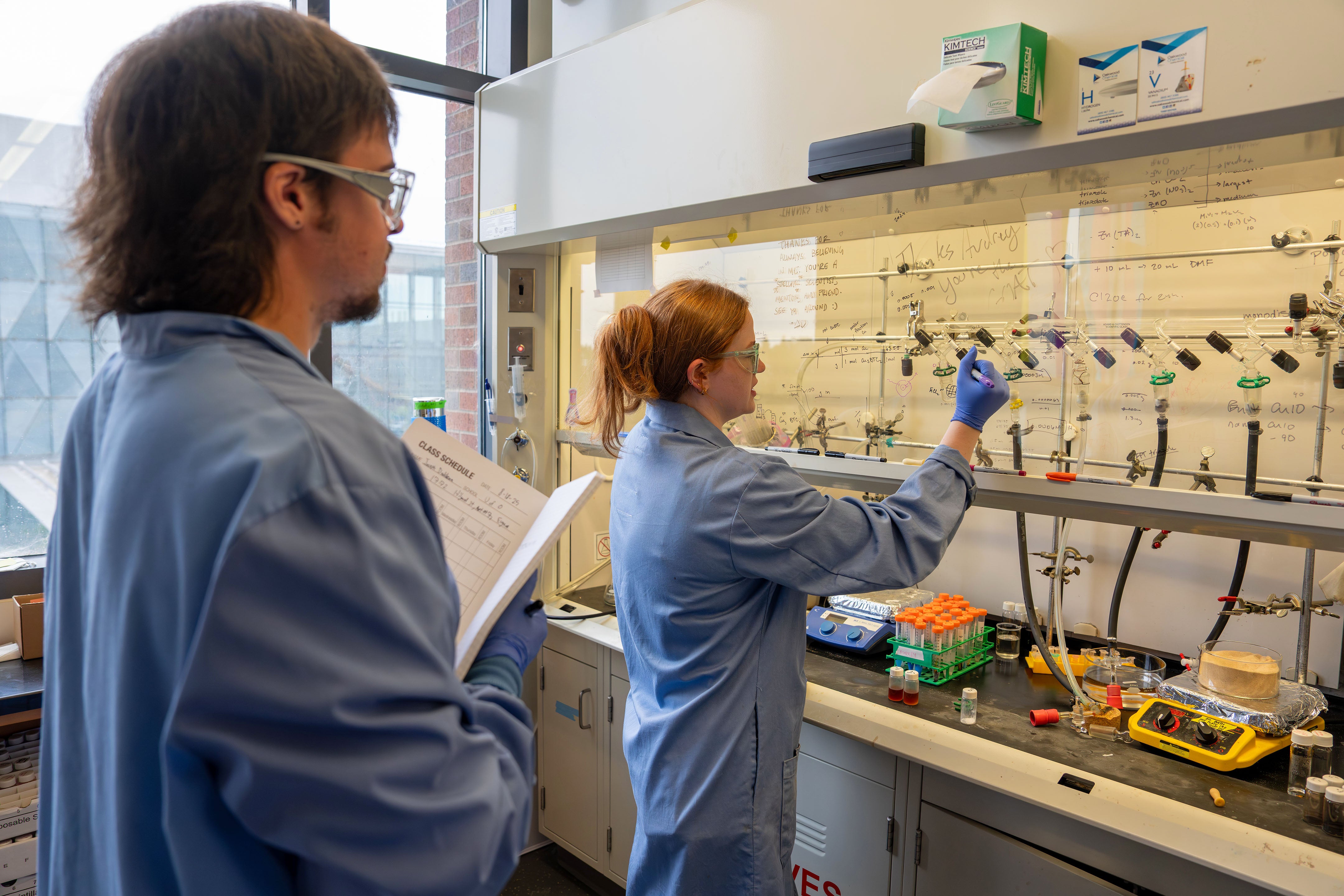 A woman and a man working in a electrochemistry lab.