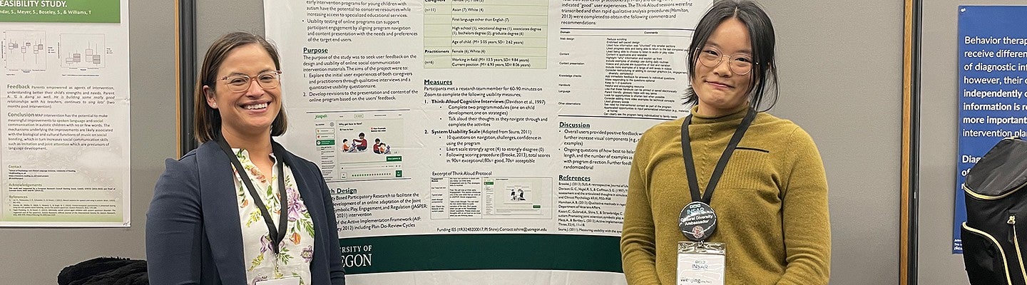 Two individuals presenting research posters