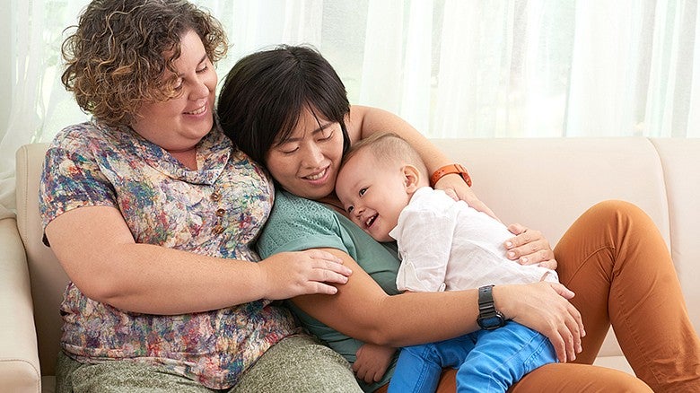 individuals sitting and cuddling while holding a baby