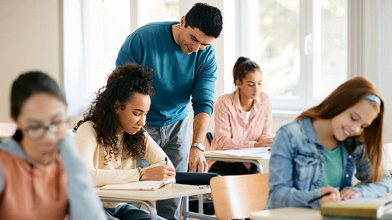 Individual with students sitting in a classroom giving instruction