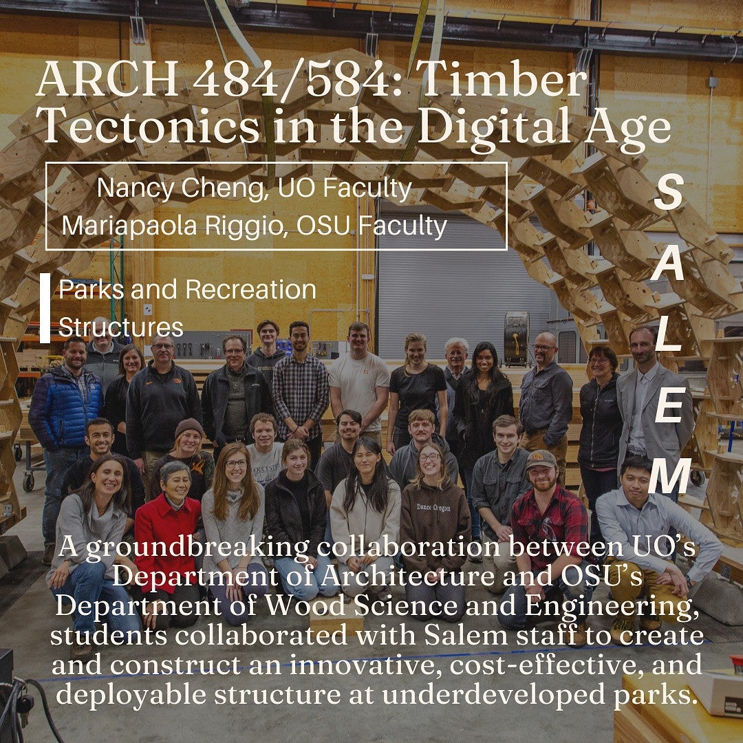 Group of students and faculty smile and pose under impressive wooden sculpture