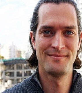 Headshot of Nico Larco smiling in front of buildings