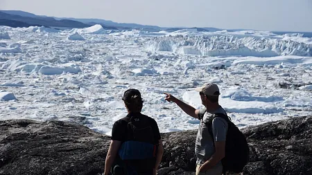 two people look over a sheet of glaciers