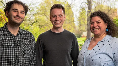 three people pose in a photo