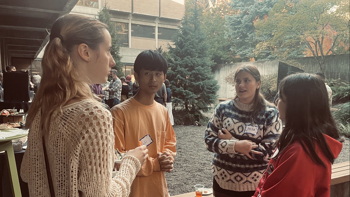 Four students standing in the McKenzie courtyard in conversation