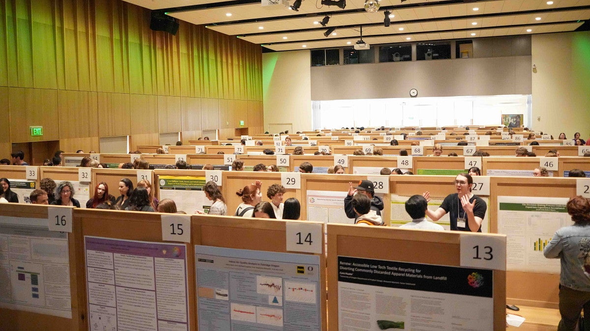 students gathered indoors presenting their research posters