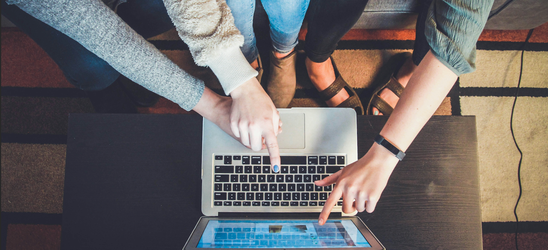 Arterial view of students pointing at laptop. Photo by John Schnobrich on Unsplash