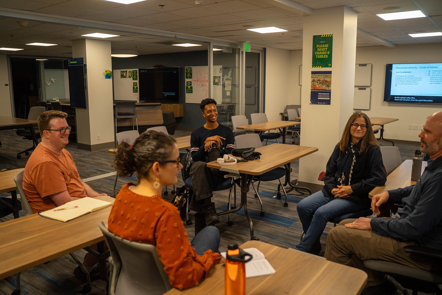 Five educators sitting and talking together
