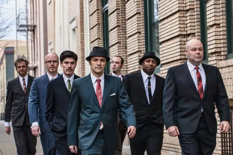 Cherry Poppin' Daddies dressed in suits walking on a city street