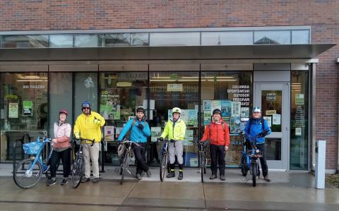 Six cyclists standing outside the EMU Bike Program with their bikes and winter cycling gear