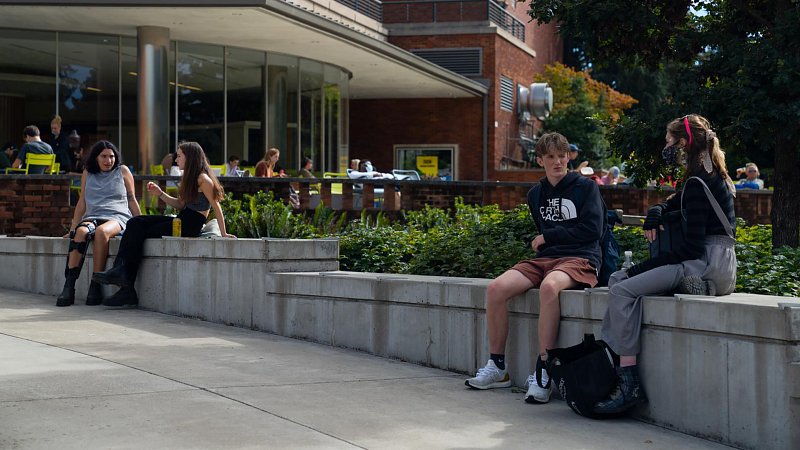 students sitting outside and talking at the erb memorial union amphitheater 