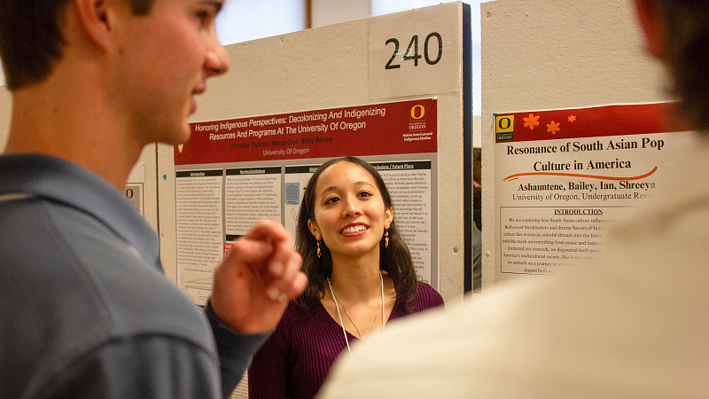 Undergraduate Research Symposium student presenting and interacting with attendees
