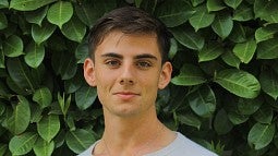 Headshot of Charles Petrik against leafy background