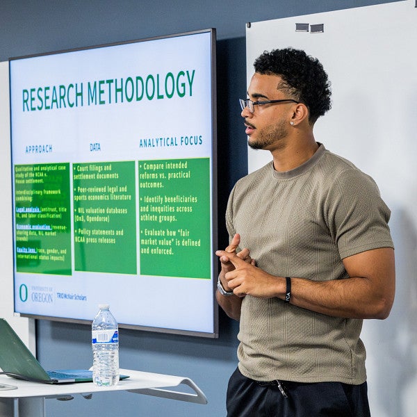 mcnair scholar delivers presentation with screen that reads "research methodology"