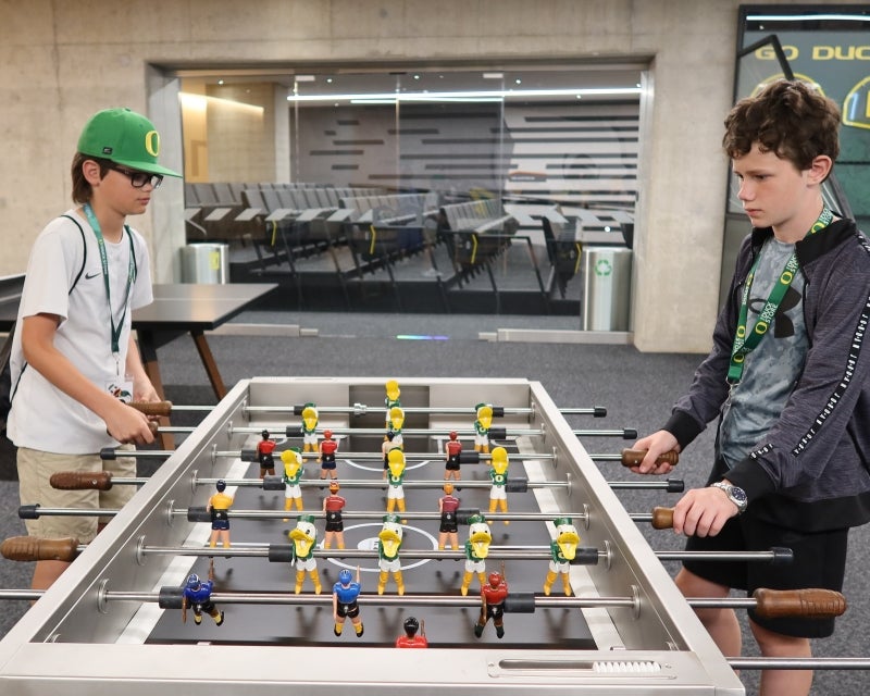 two kids playing foosball in the student athlete lounge