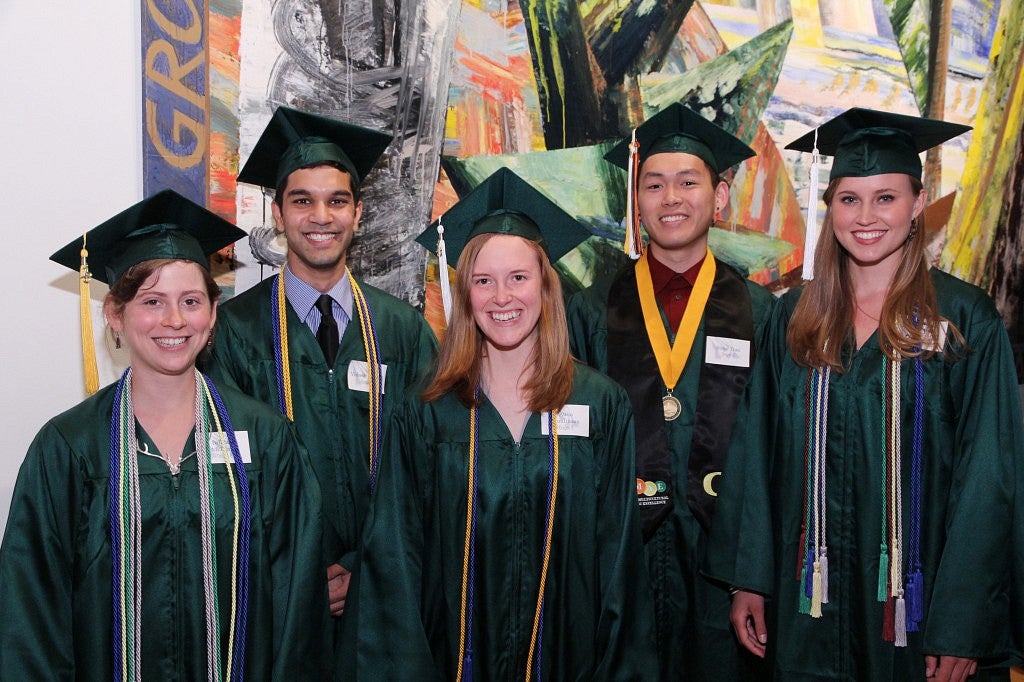 5 members of the 2013 Oregon Six pose as a group in their cap and gowns.