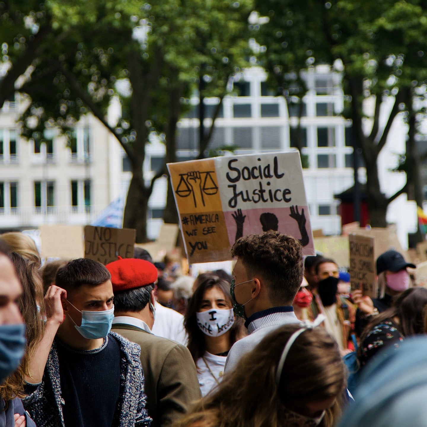A crowd of social justice protestors wearing protective masks