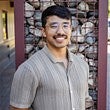 Eddy Stoddard has short black air, glasses and a mustache