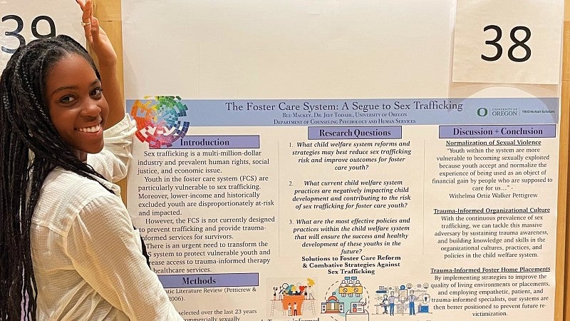Blu Mackey poses with her poster presentation