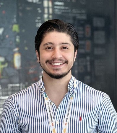 Danial DlShad in a stripped shirt looking at the camera and smiling