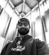 Yash Akhouri has a beard and backwards ball cap. Photo is black and white.