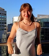 Vivian Reynolds has long light brown hair and wears a silver dress