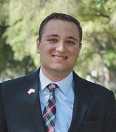 Andy Essa wears a suit with a plaid tie