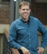 Chris Minson. He has short sandy blonde hair and a blue shirt