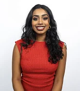 Harini Sachidhanand has long dark brown hair and wears red