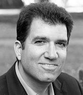 Michael Malek Najjar. He has short black hair. Photo is black and white.
