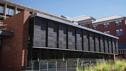 Price Science Commons library exterior - red brick, glass, and greenery