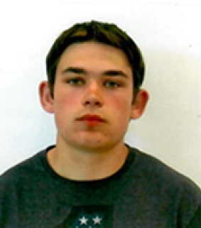 Young man with short brown hair and dark sweater looks at the camera