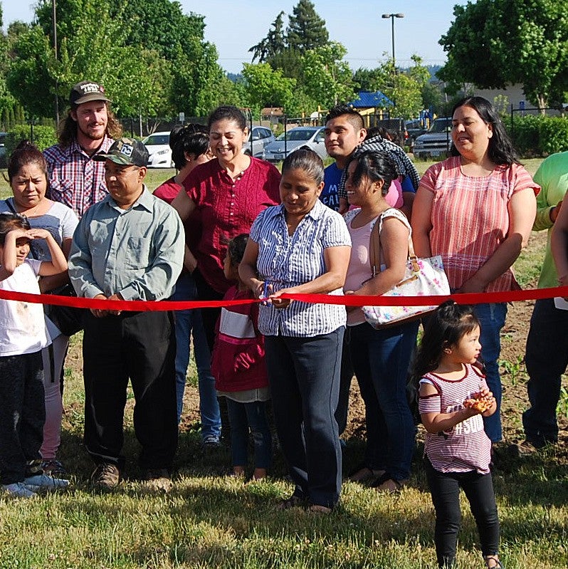photo of people cutting ribbon on new Huerta de la Familia garden