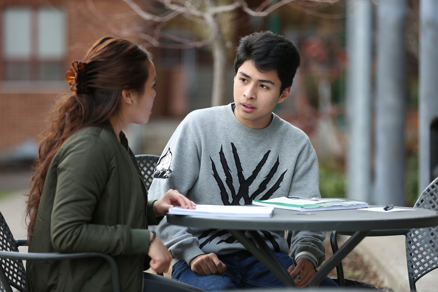 Two students sitting at a table on campus talking