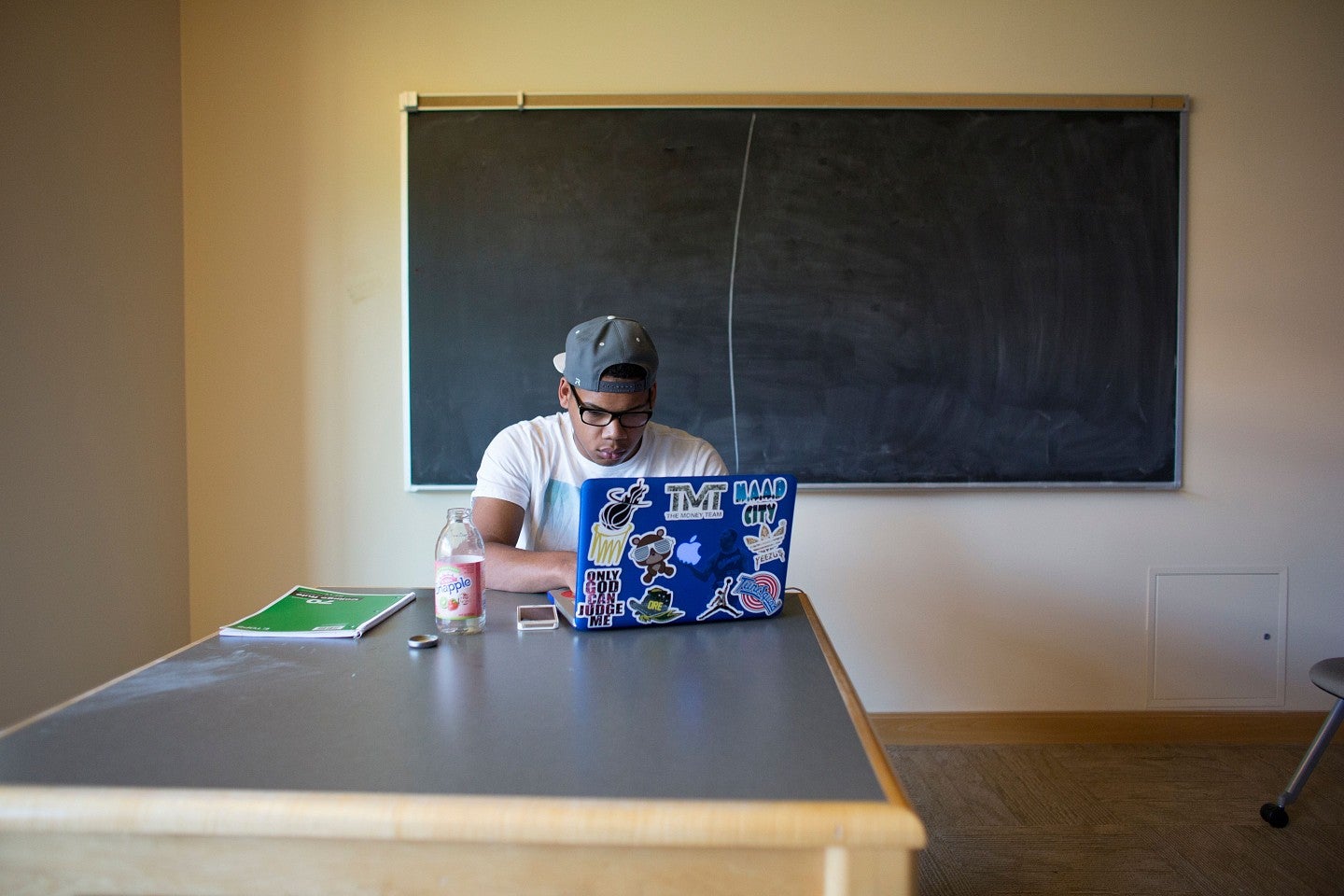 Student sits at table with laptop using the GPA calculator