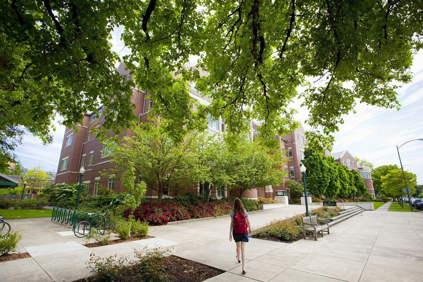 Student on University of Oregon campus walks towards campus building