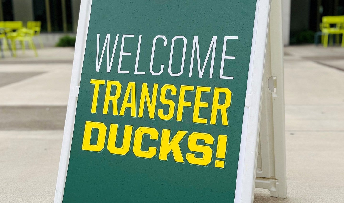 a green sandwich board sign that says "welcome transfer ducks"