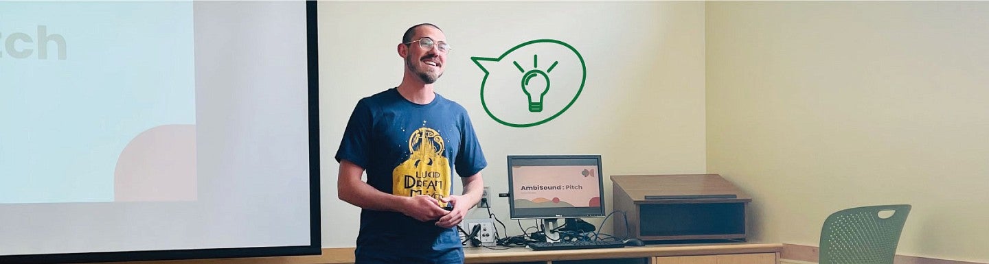 A student stands at the front of a classroom and pitches a business venture