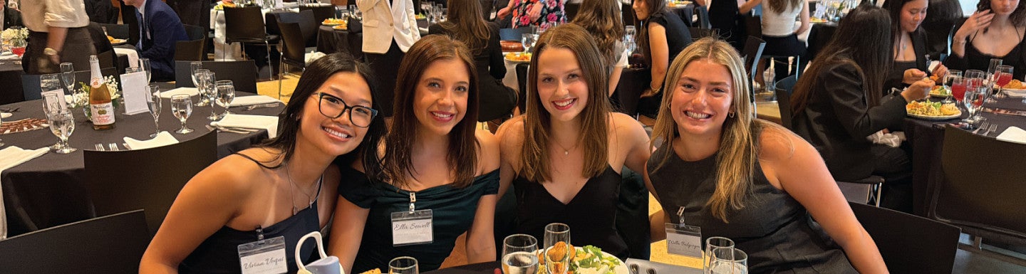 Student club members pose for a group photo while seated at a table during the 2025-2026 Dean's Council for Inter-Club Coordination End of Year Gala