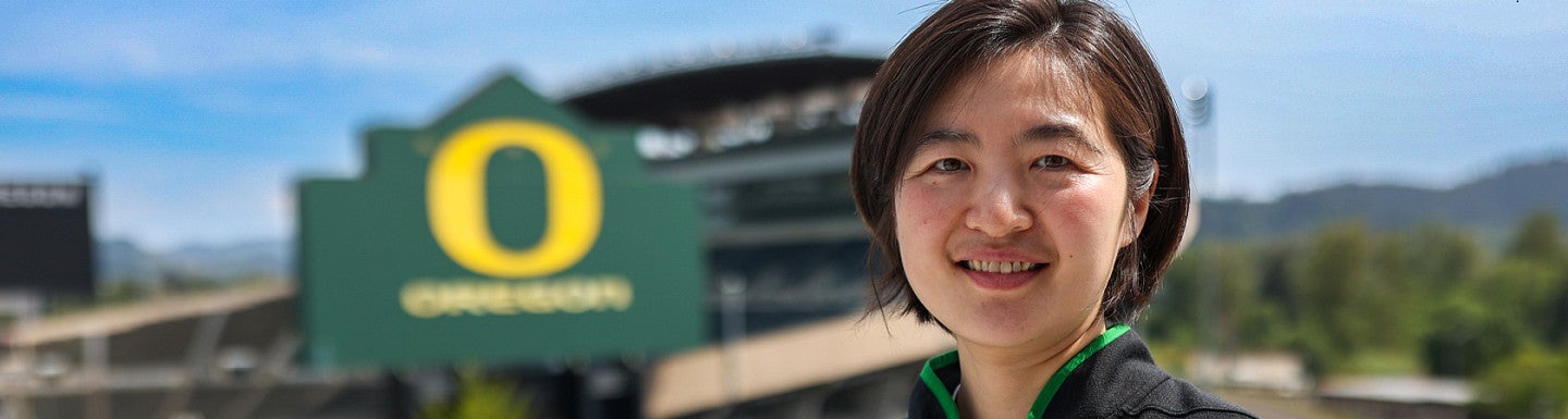 Alicia smiles while standing in front on Autzen Stadium.