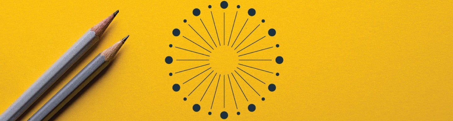 Two pencils sit on a yellow surface