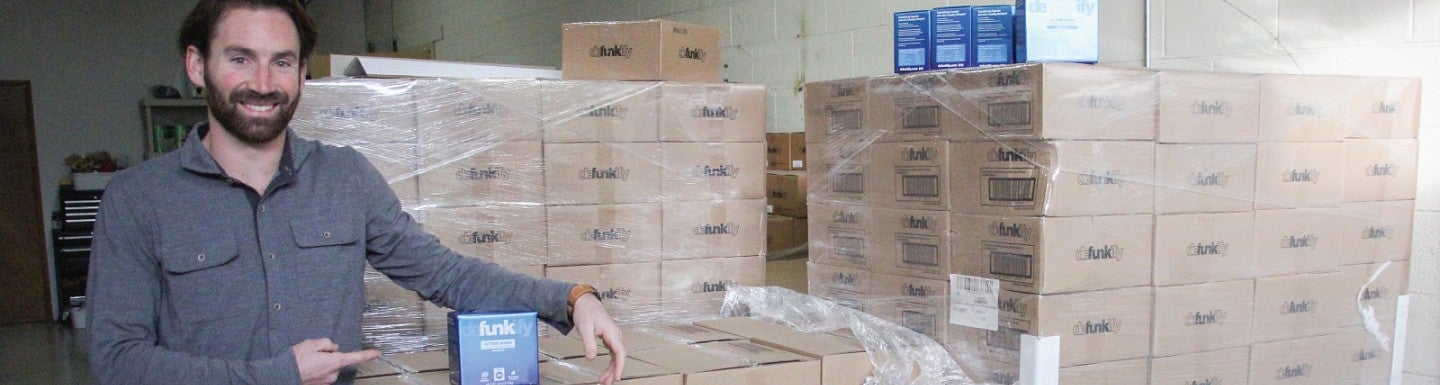 Defunkify Chief Marketing Officer Eddie Rosenberg poses beside a palette of the product