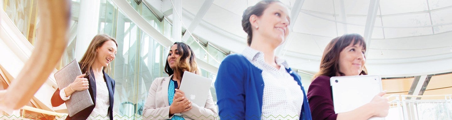 MBA students descend the stairs in the Lillis Business Complex