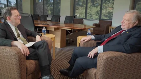 Photo of Michael Schill and Chuck Lillis sitting in chairs facing each other while talking for this video interview