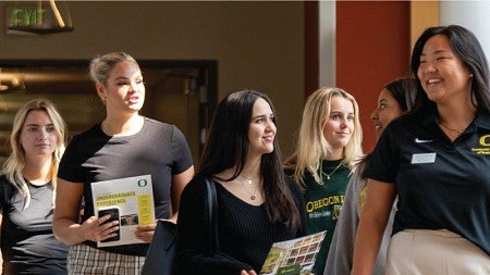 A Duck Guide leads prospective students on a tour of the Lillis Business Complex
